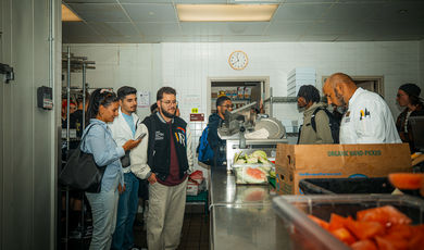 Students watch a man prepare food 