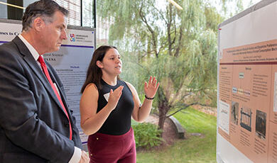 A BSU student presenting and discussing her research poster at the BSU Undergraduate Research Symposium