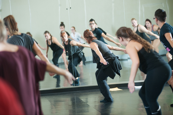 Professor Jodi Weber leading a modern dance class as they all dance facing a mirror