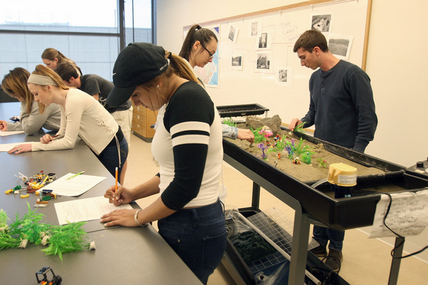 Physical Geography class with 2 students using a streaming table while others take notes at a lab table