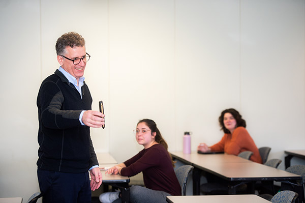 Professor James Feeney holding out a teaching aid while teaching a class