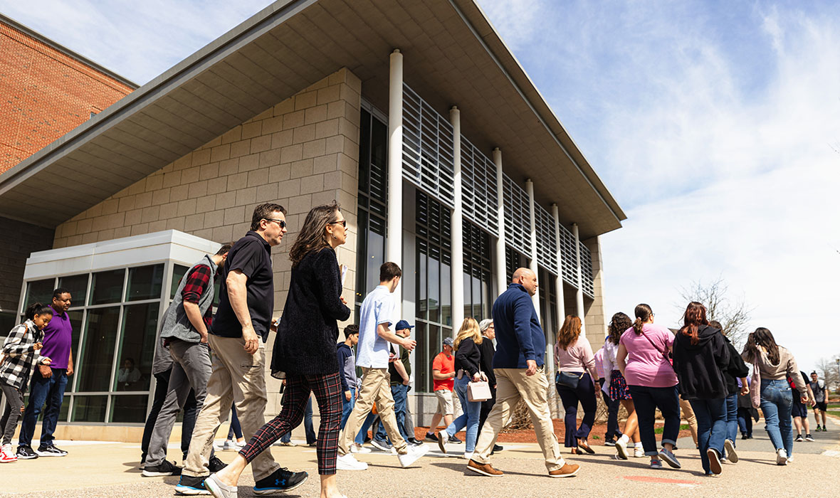 A group of alumni walking through campus, on a tour