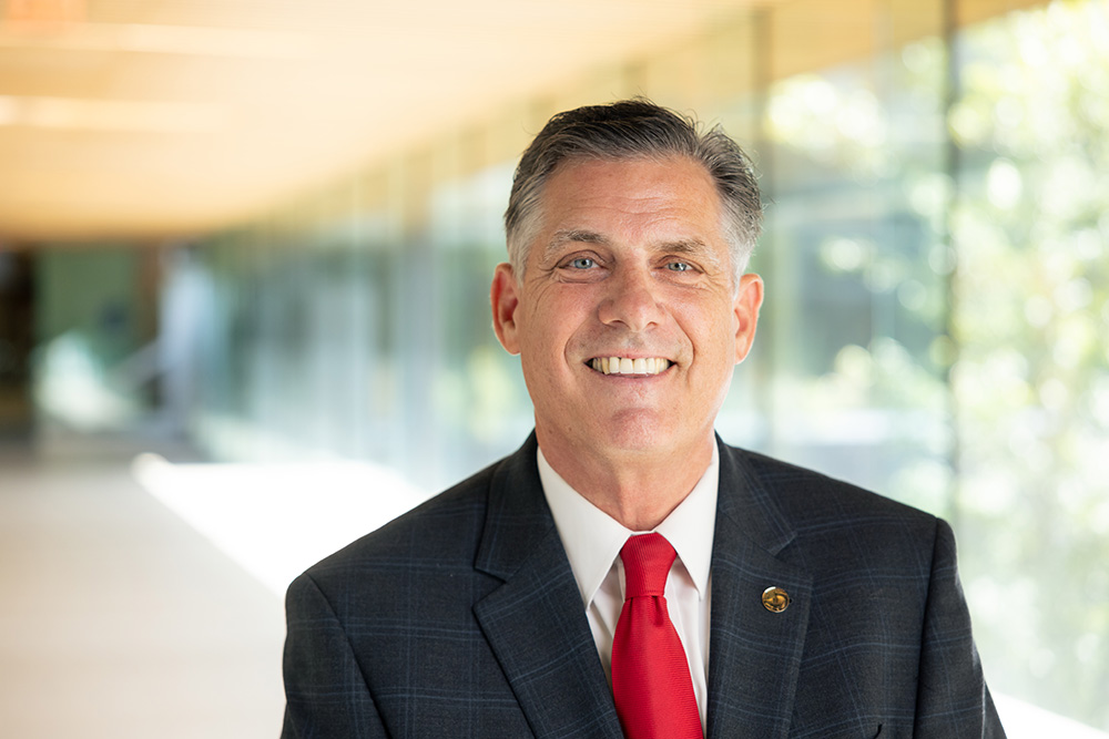 BSU president Fred Clark smiling for the camera in a sunlit corridor