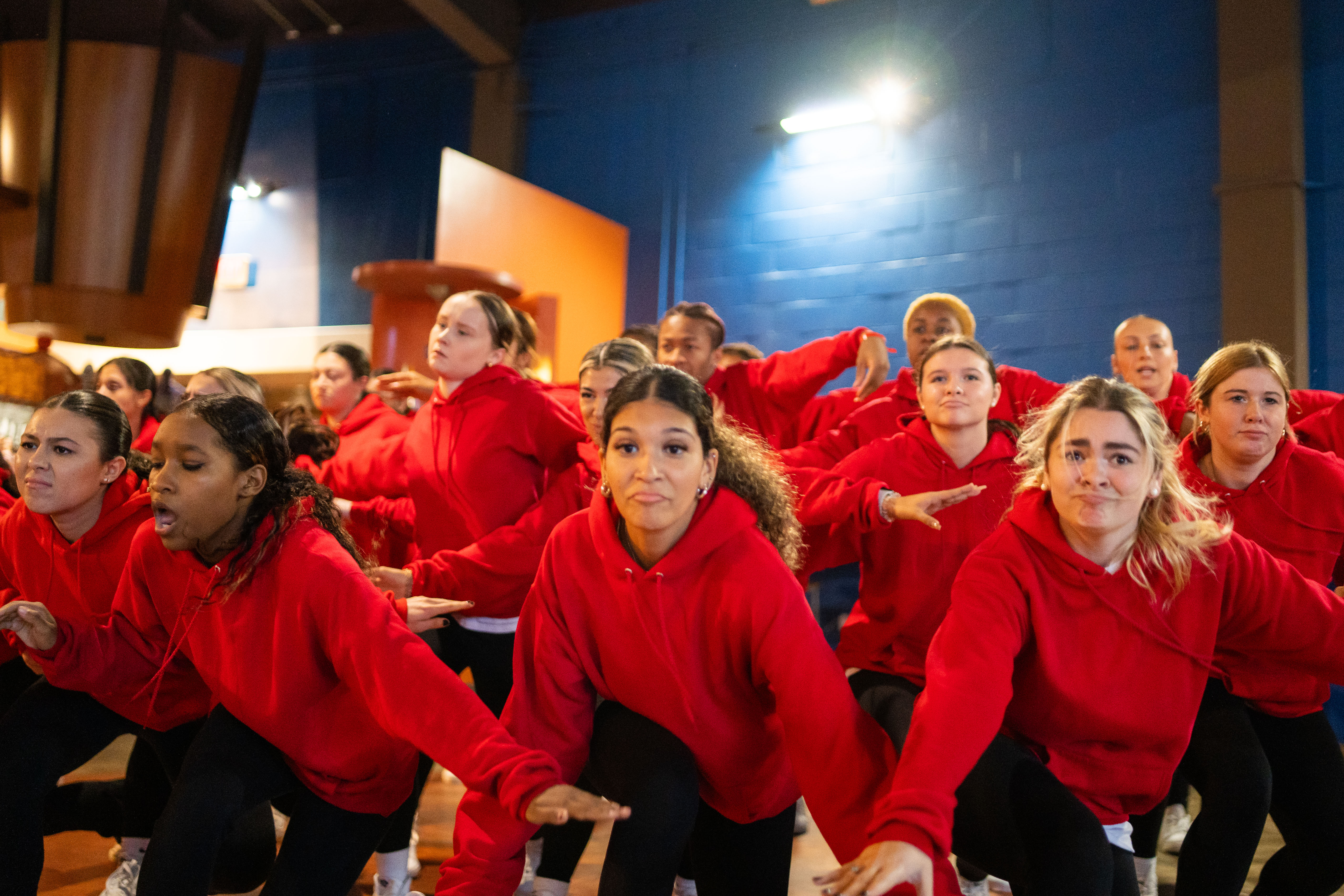 A group of BSU dancers wearing red sweatshirts and black pants perform