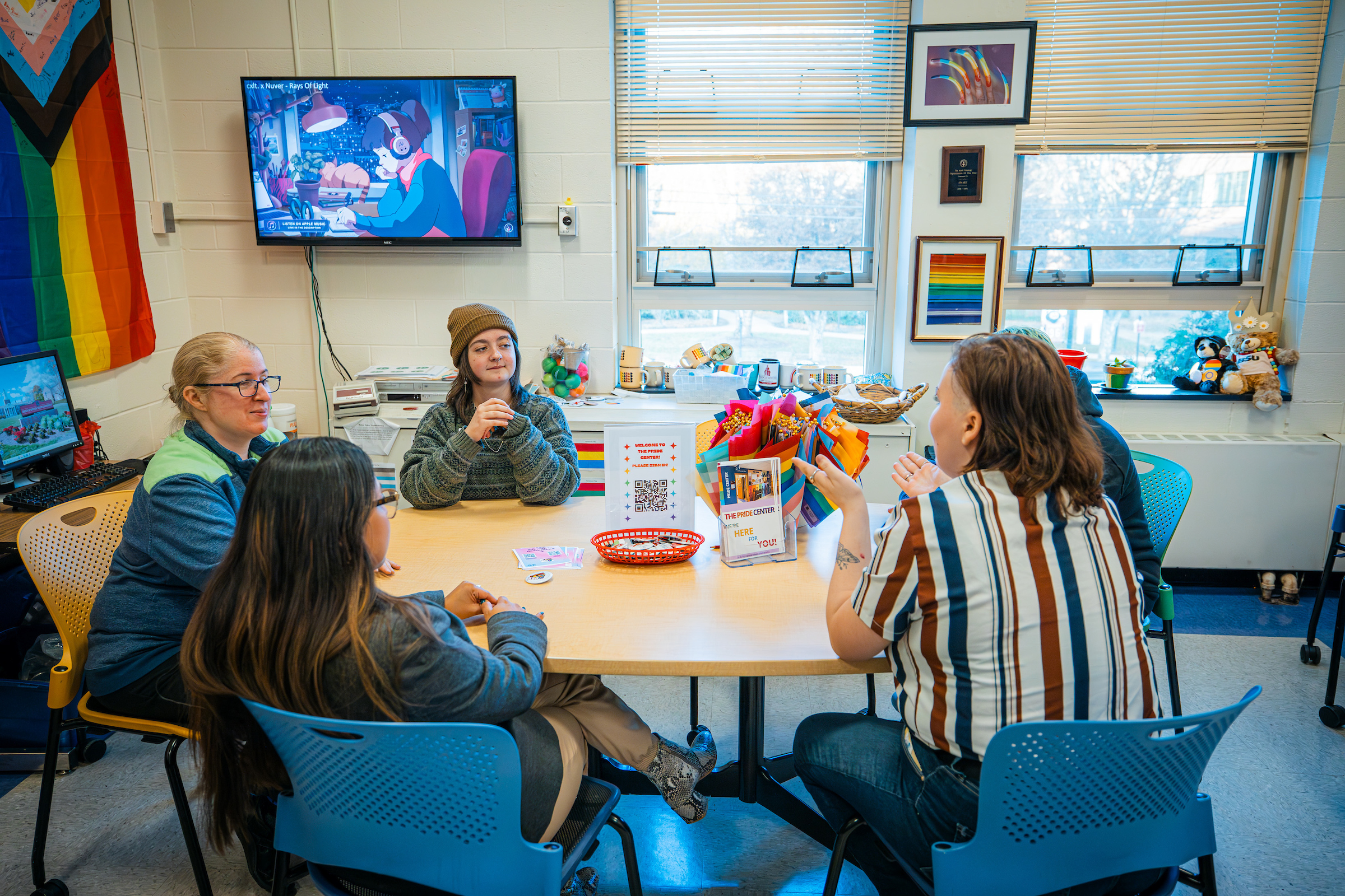 Pride Center director and students sit around a table in the center talking