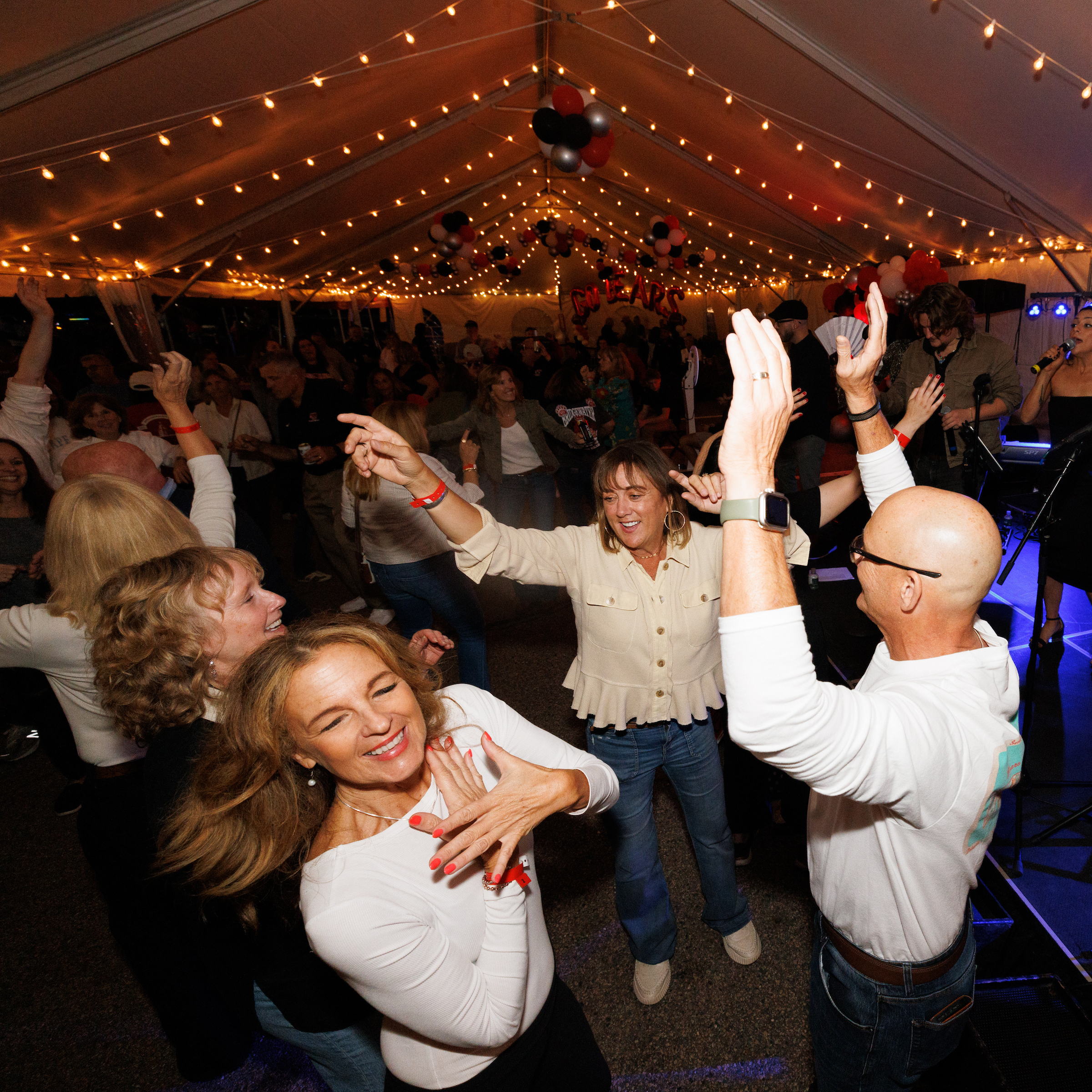alumni dancing in the Alumni Homecoming Tent