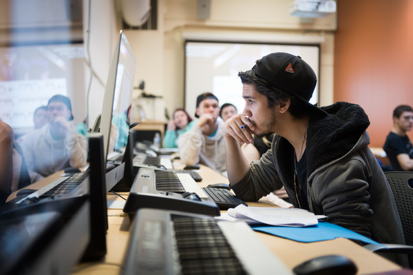 students in a music class sitting at keyboards and looking at computers