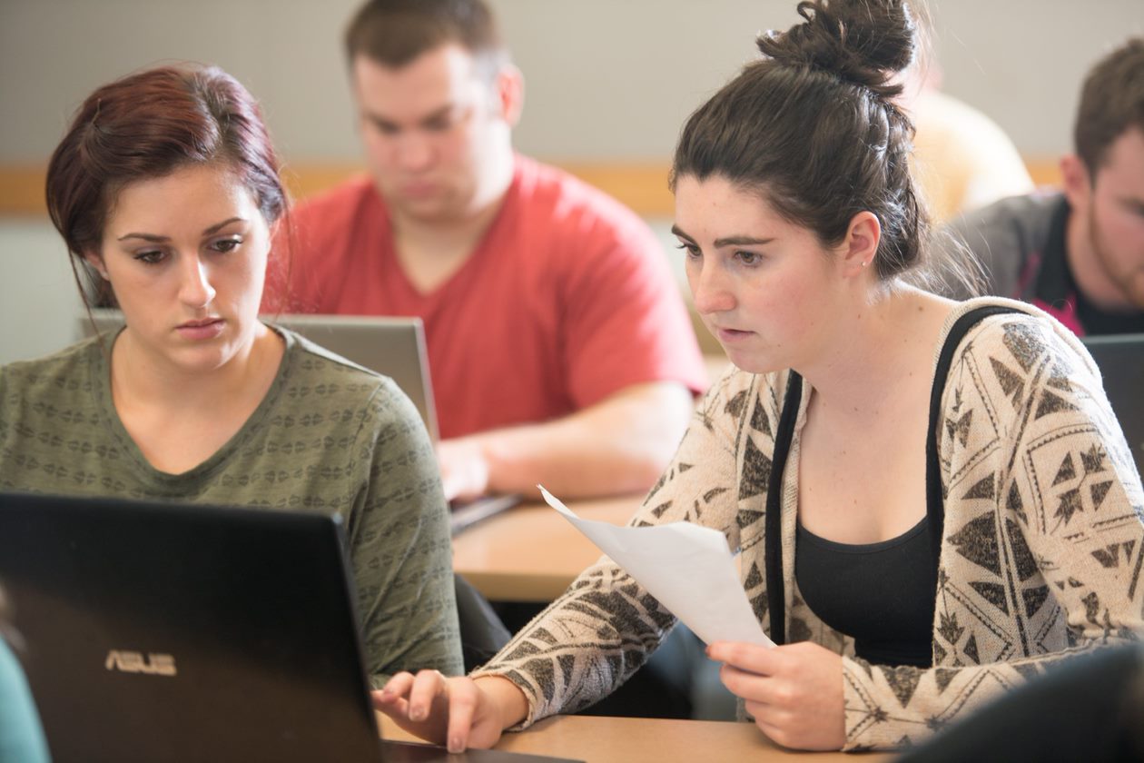 students working on laptop in class
