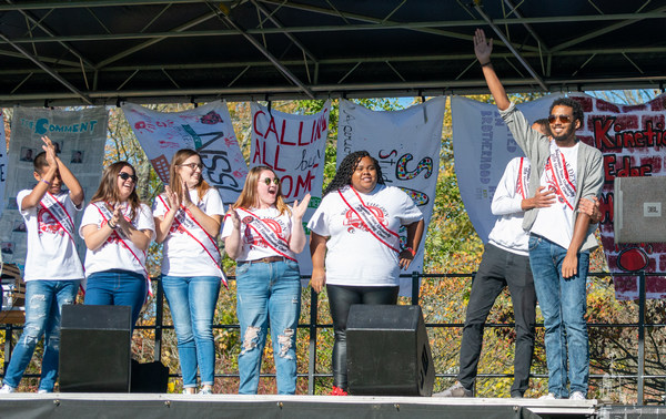 Students-2019.10.19 Homecoming-CP-600w.jpg 2019 Homecoming court on stage smiling and clapping