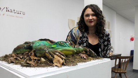 Ari Barrett stands next to a frog sculpture she made.
