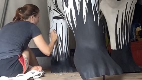 Sam Cushman paints a leg of the bear.