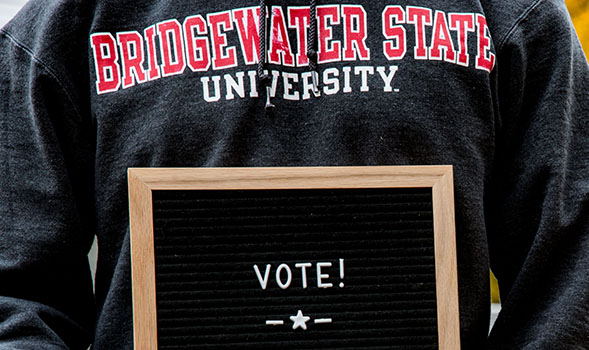 A person in a BSU sweatshirt holding a letter board that says VOTE