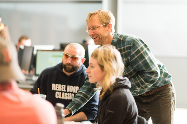 Dr. Rob Hellstrom helping 2 students while teaching Cartography class