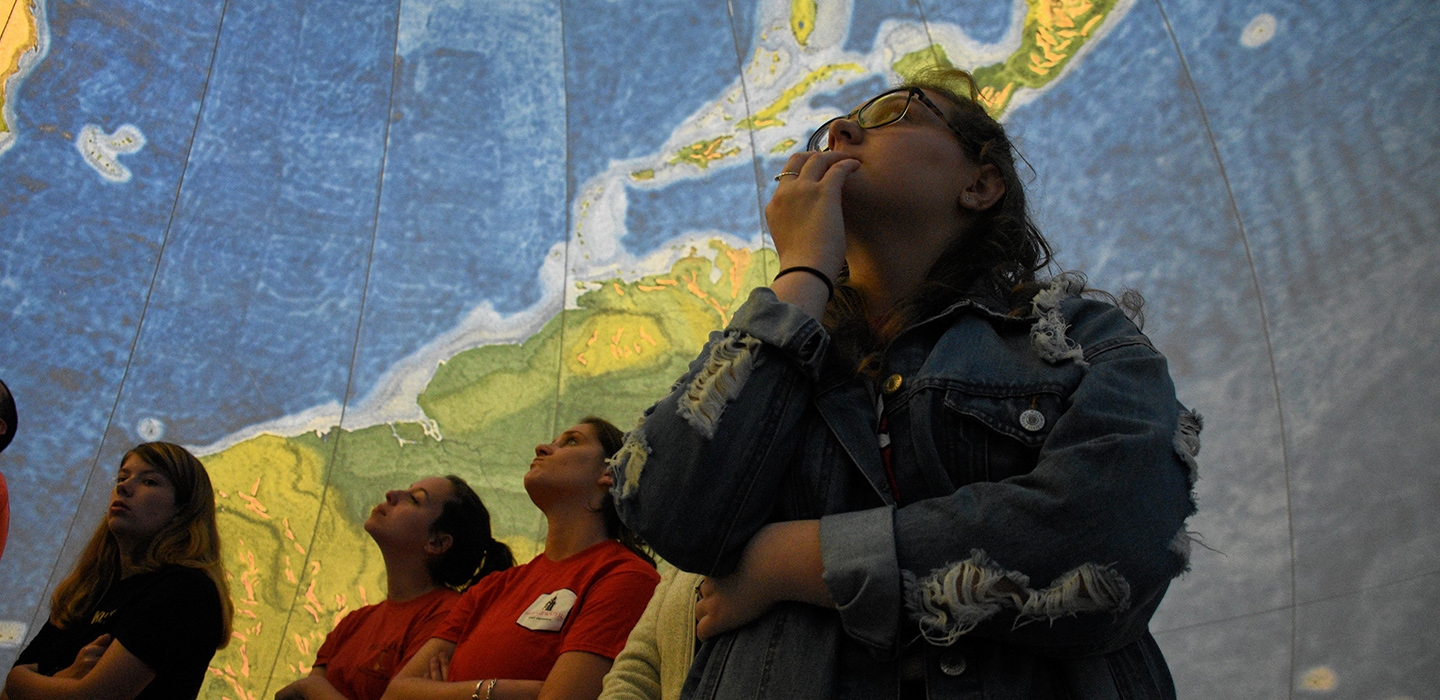 High school students touring the inside of an Earthview globe