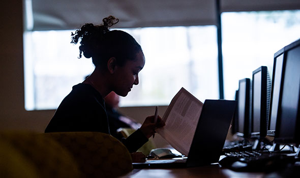 Silhouette of a student taking notes in class