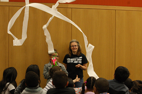 BSU Professor Susan Savill, wearing a t-shirt that says &quot;With enough thrust pigs fly just fine,&quot; has an elementary student demonstrate a gadget that blows air on a roll of toilet paper and makes it unroll into the air