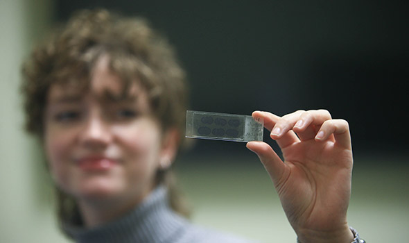 hartgrove-ug-research-0822.jpg Psychology student Cassandra Hartgrove, '22, holds up a slide with samples from monkey brains