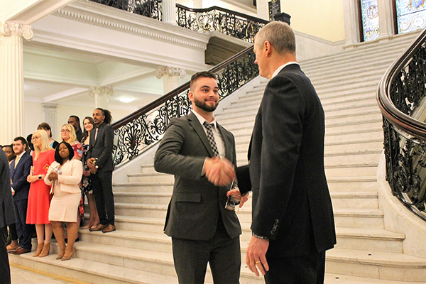 BSU student shaking Governor Charlie Baker's hand at the Massachusetts state house