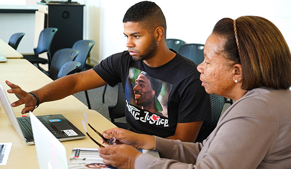 BSU Director of Internships, Diane Bell, works with a student who points to something on a laptop