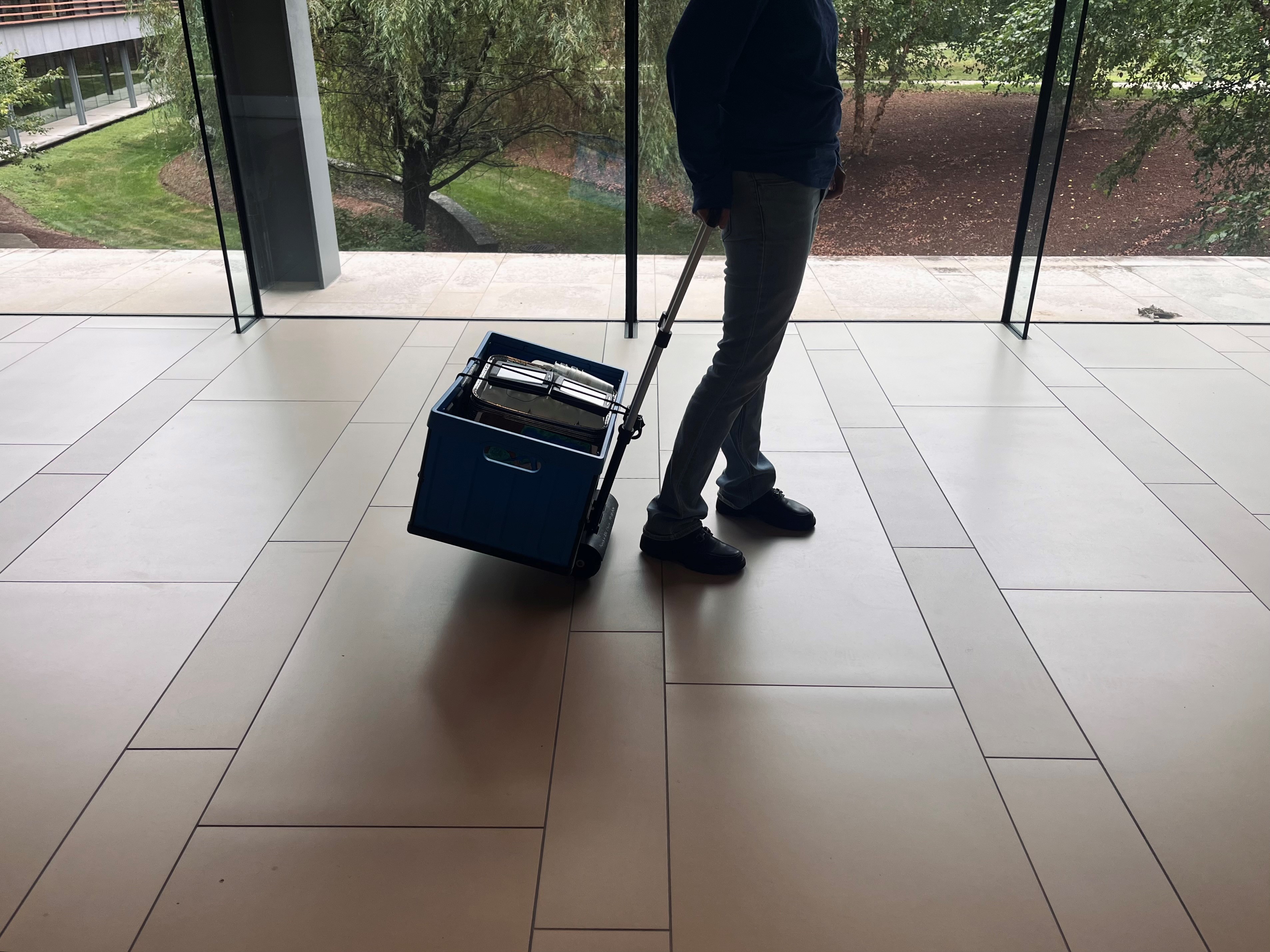 An instructor pulls a rolling caddy filled with science kits