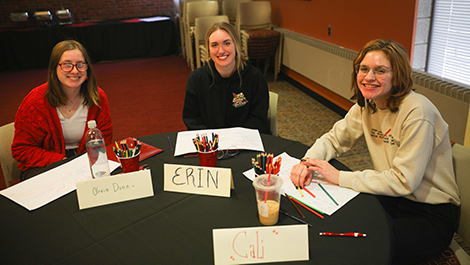 Three students sit at a table drawing mind maps during a Life Design workshop.