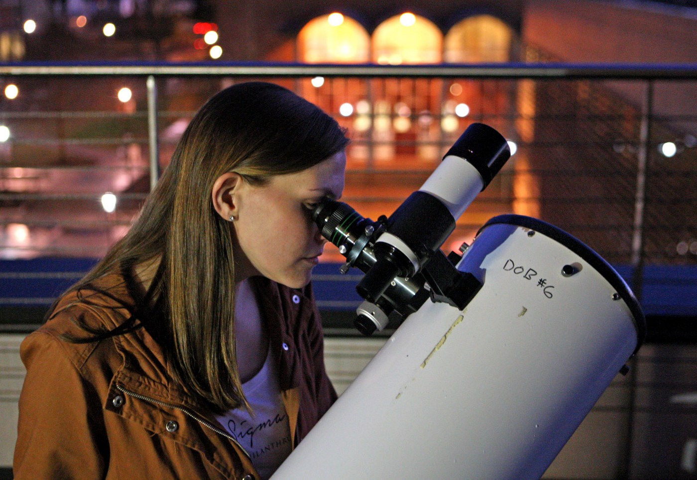 woman looking into a telescope