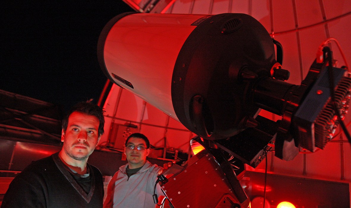 students inside observatory with large telescope