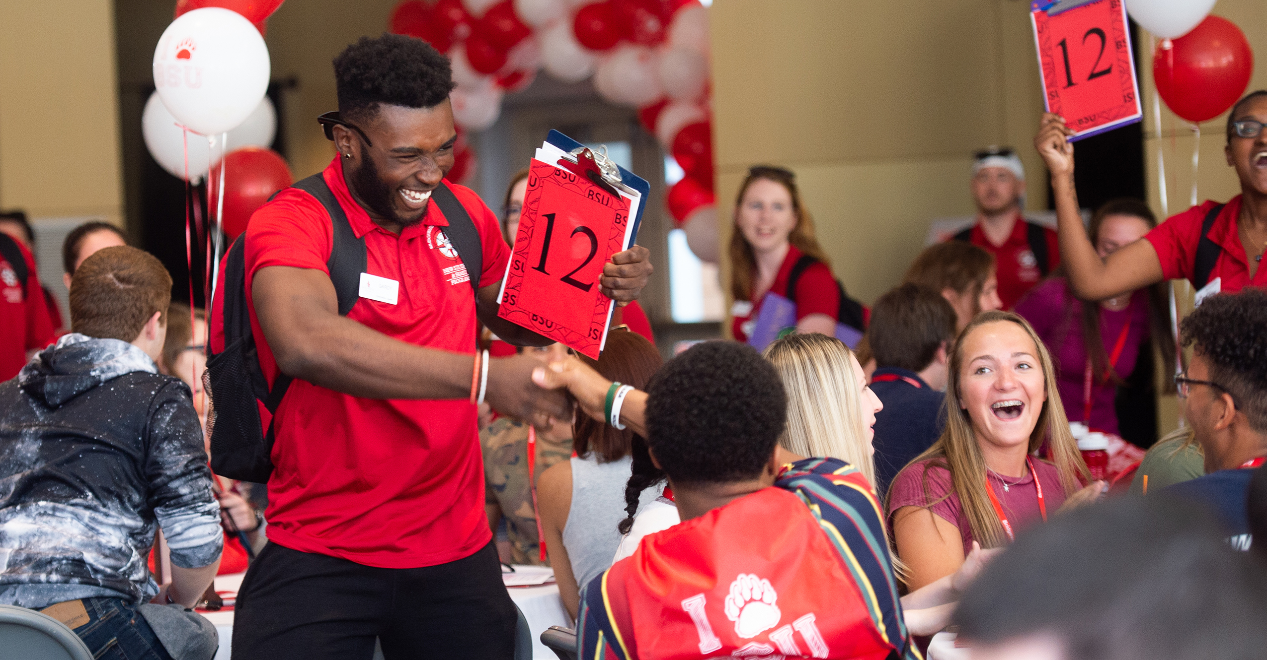 orientation2-full-width.jpg An orientation leader shaking hands with a new student
