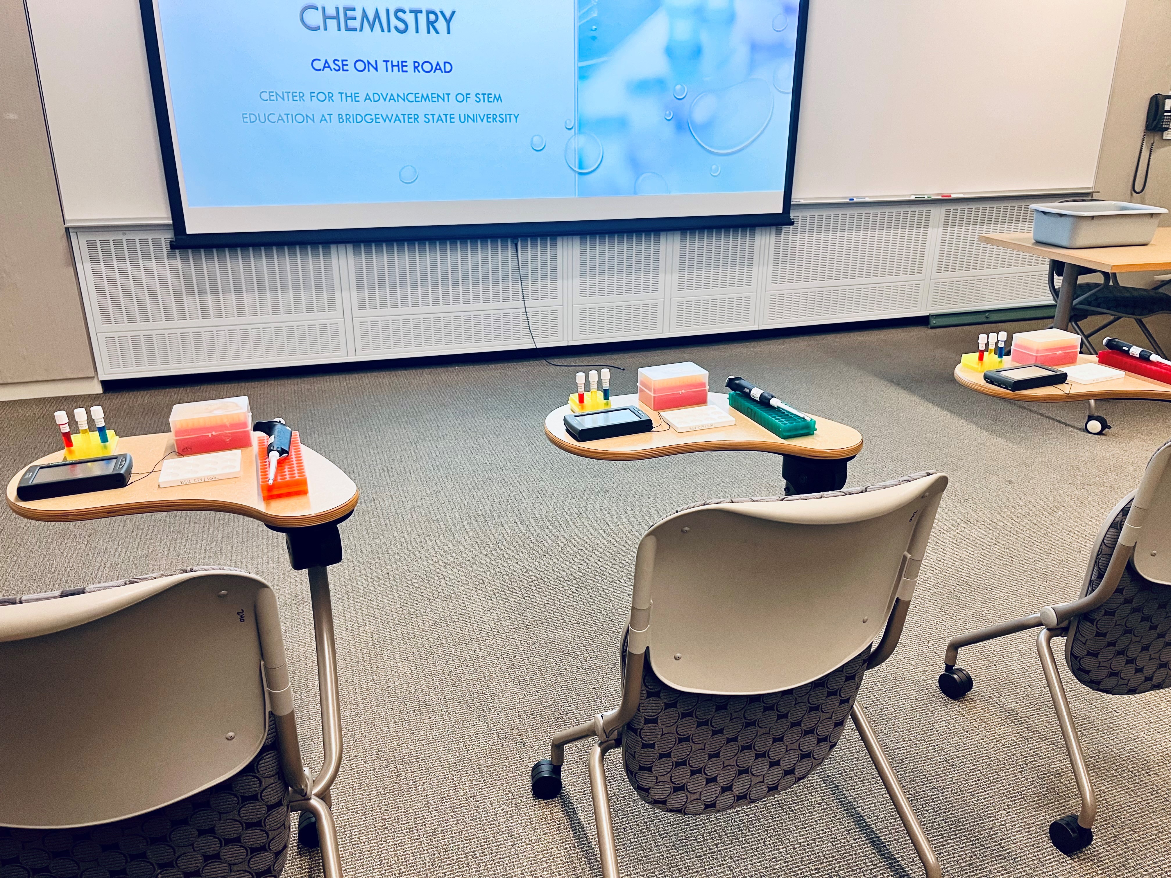 A classroom with individual desks, each set up with a science experiment kit