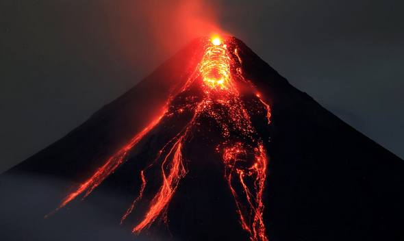 an active volcano with hot lava flowing down it and red gases emanating off the top