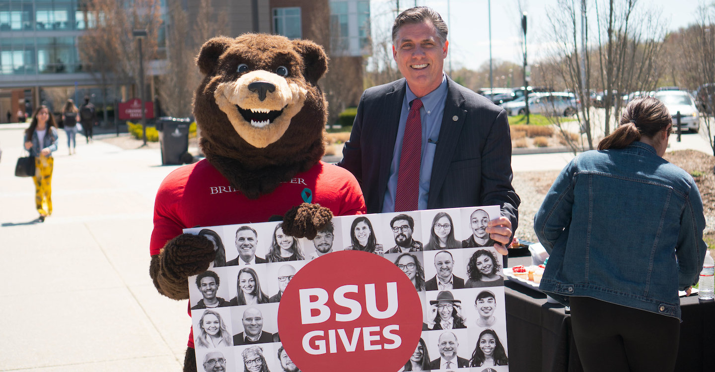 Bristaco the Bear and President Fred Clark pose with a BSU Gives Poster