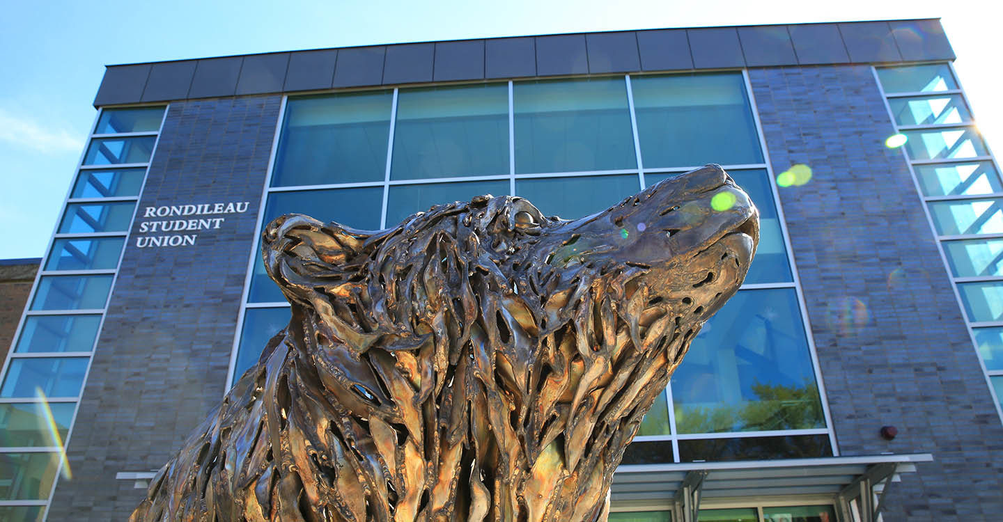The bear sculpture in front of Rondileau Student Union
