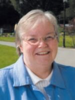 Headshot of Jean Stonehouse in front of a grassy area and sidewalk.
