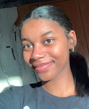 Cintia Mascarenhas smiling with medium length straight black hair and wearing a dark gray top