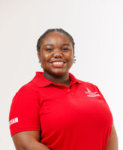 Cynthia Esterlin smiling with short braided black hair and wearing a red BSU Orientation Leader polo