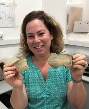 Linda Meiberg holding 2 pieces of broken pottery