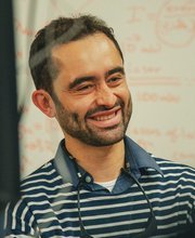 Samuel Serna Otalvo smiling in front of a white board