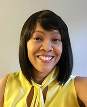 headshot photo of Sandy Beauvoir smiling  with straight shoulder length black hair wearing a sleeveless yellow blouse