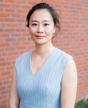 Dr. Alice Cheng smiling with her straight dark hair pulled back wearing a light blue sleeveless v-neck top