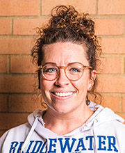 headshot photo of Dr. Taylor Hall with light brown curly hair pulled up wearing glasses and a white BSU sweatshirt