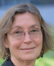 headshot photo of Dr. Karen Hamilton smiling with medium length light brown hair with gray in it and wearing thin wire rimmed glasses