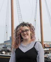 Carolyn King, '23, posing in front of a sailing ship