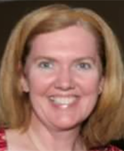 Kelly McMorrow smiling with medium length dirty blonde hair wearing a brown headband and a pink patterned top