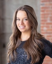 headshot photo of Chrissy Semler smiling with long brown hair and wearing a black top