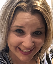 Close up headshot photo of Shannon Snyder smiling with shoulder length brownish blonde hair