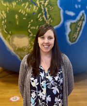 Courtney Sutcliffe standing in front of giant inflatable globe smiling