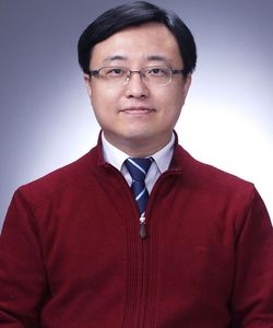 a dark haired man with glasses in a red sweater