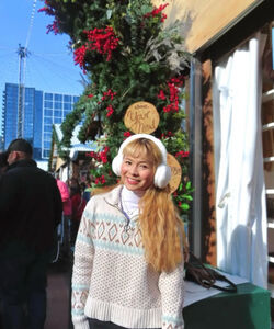 a long-haired, smiling woman wearing white earmuffs