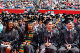 BSU students sitting in rows at Commencement and smiling