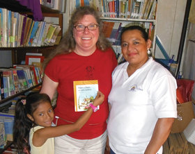 Pamela Hayes-Bohanan joins librarian and teacher Jacoba Cantarero and a young girl named Paola